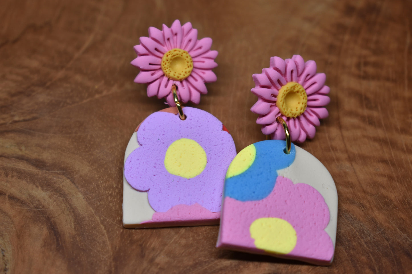 Handcrafted polymer clay arch earrings with pink daisy stud and pastel floral pendant in lilac, blue, pink and yellow