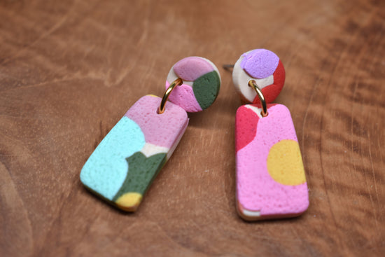 Handcrafted polymer clay drop earrings with mismatched abstract blob circle stud and rectangle pendant in pink, teal, red and yellow
