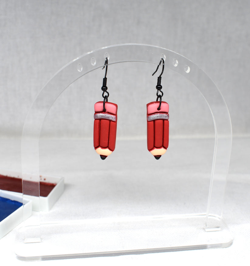 Handmade chunky red polymer clay pencil earrings with pink eraser top, silver ferrule band and black graphite tip on matte black hooks