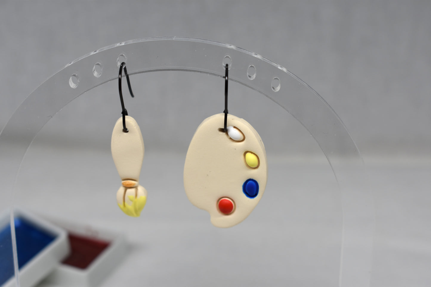 Handmade polymer clay mismatched paintbrush and artist palette earrings with yellow bristle tip on matte black hooks