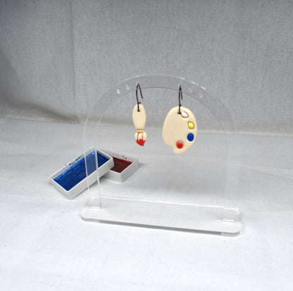 Handmade polymer clay mismatched paintbrush and artist palette earrings with red bristle tip on matte black hooks